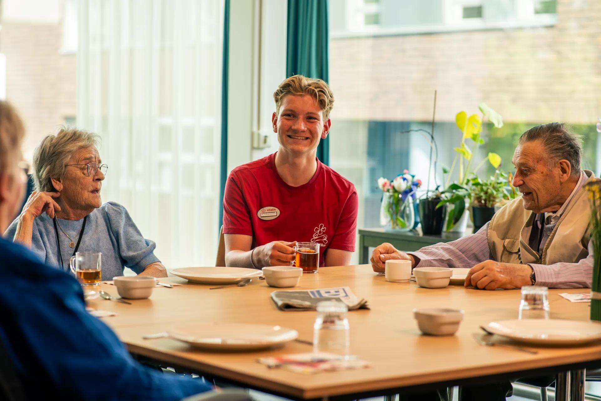 Een medewerker met 2 ouderen aan tafel