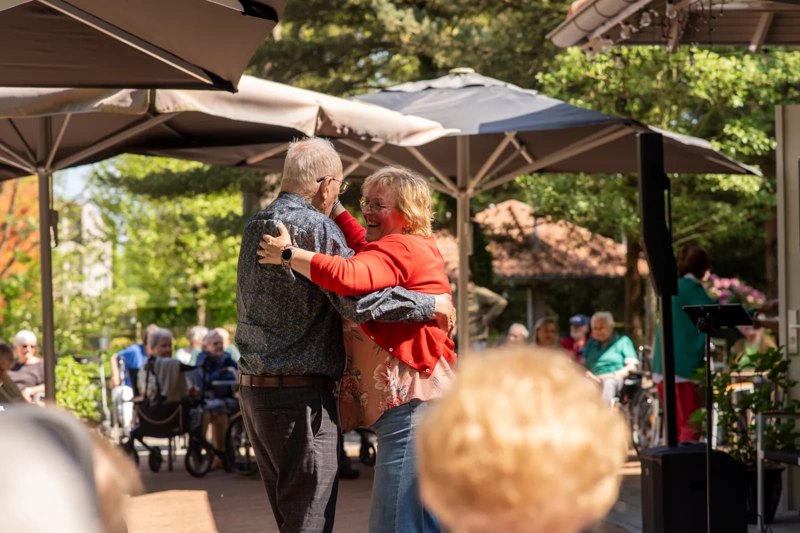 Een activiteitenbegeleidster met een oudere zijn samen aan het dansen