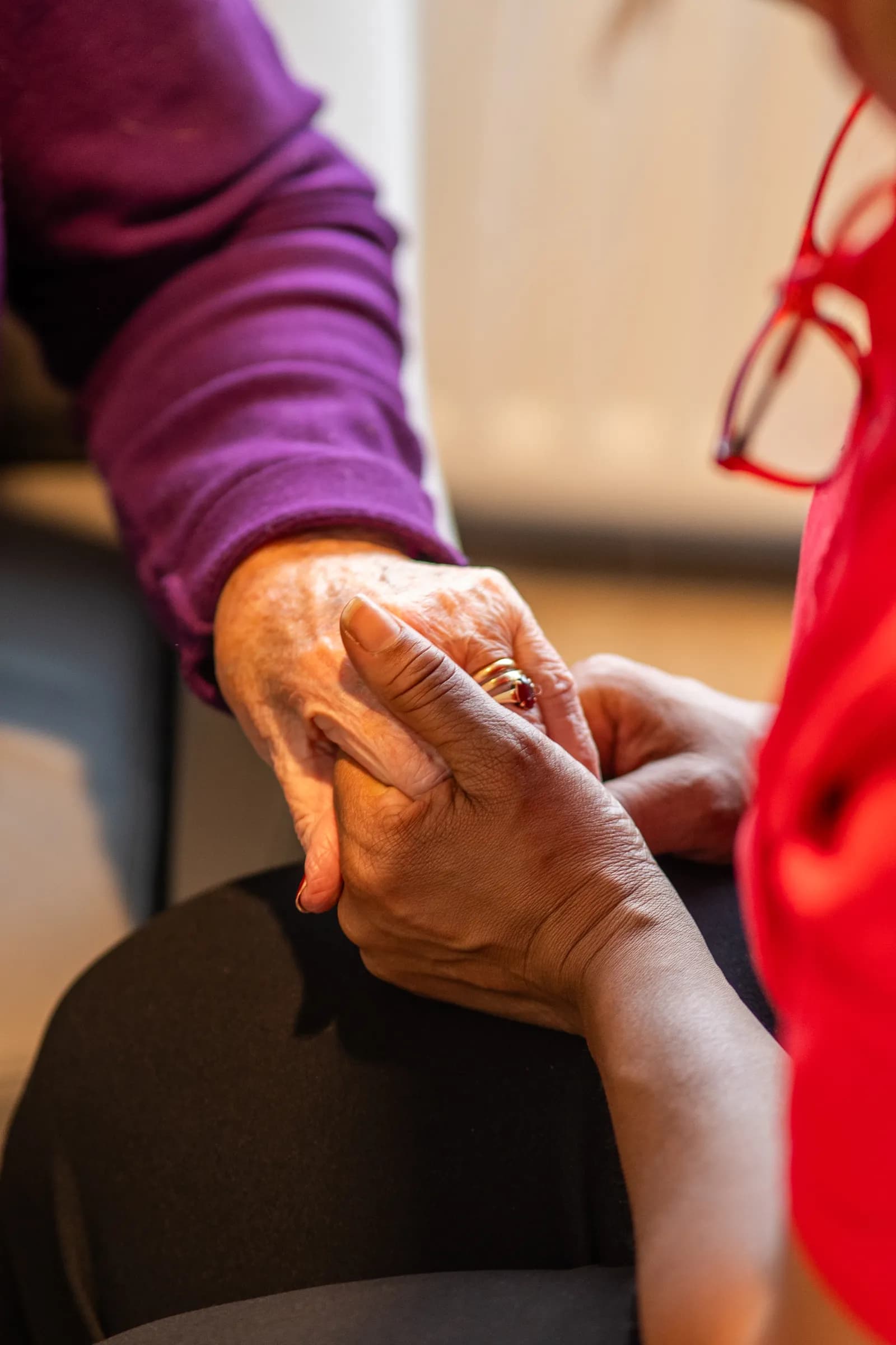 Zorgmedewerker houdt hand vast van oudere