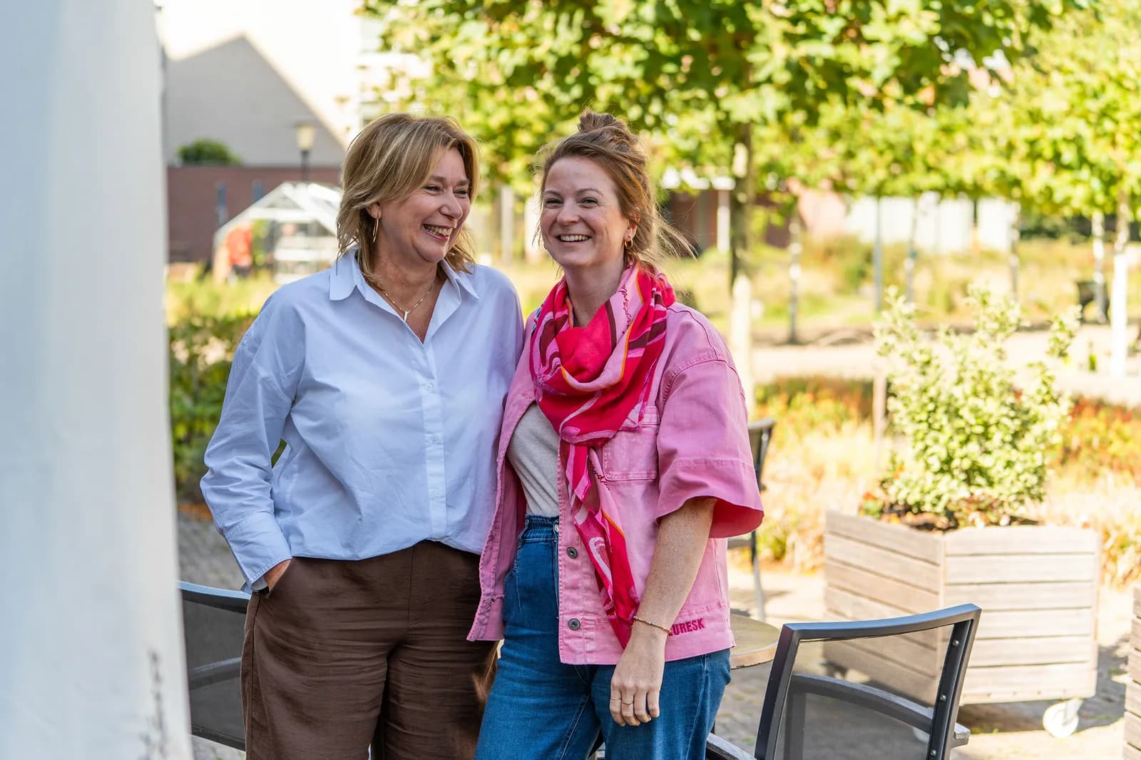 Twee vrouwen lachen naar elkaar en de camera | Vitalis