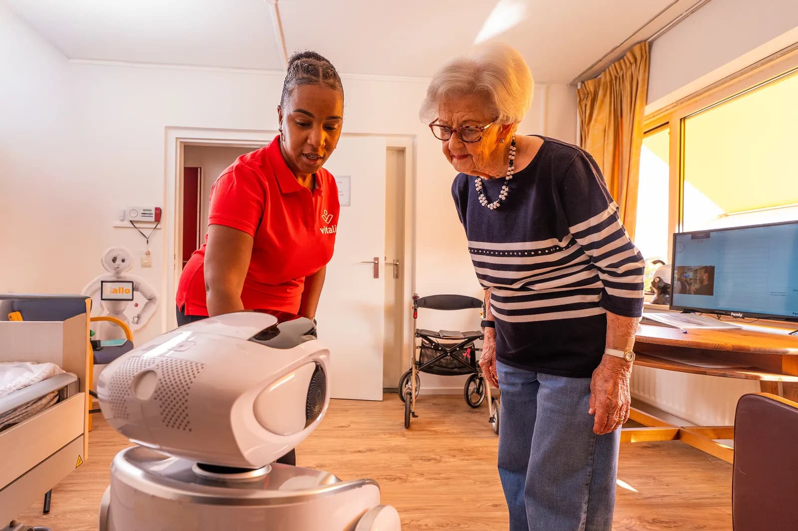 Een medewerker, een oudere en een zorgrobot