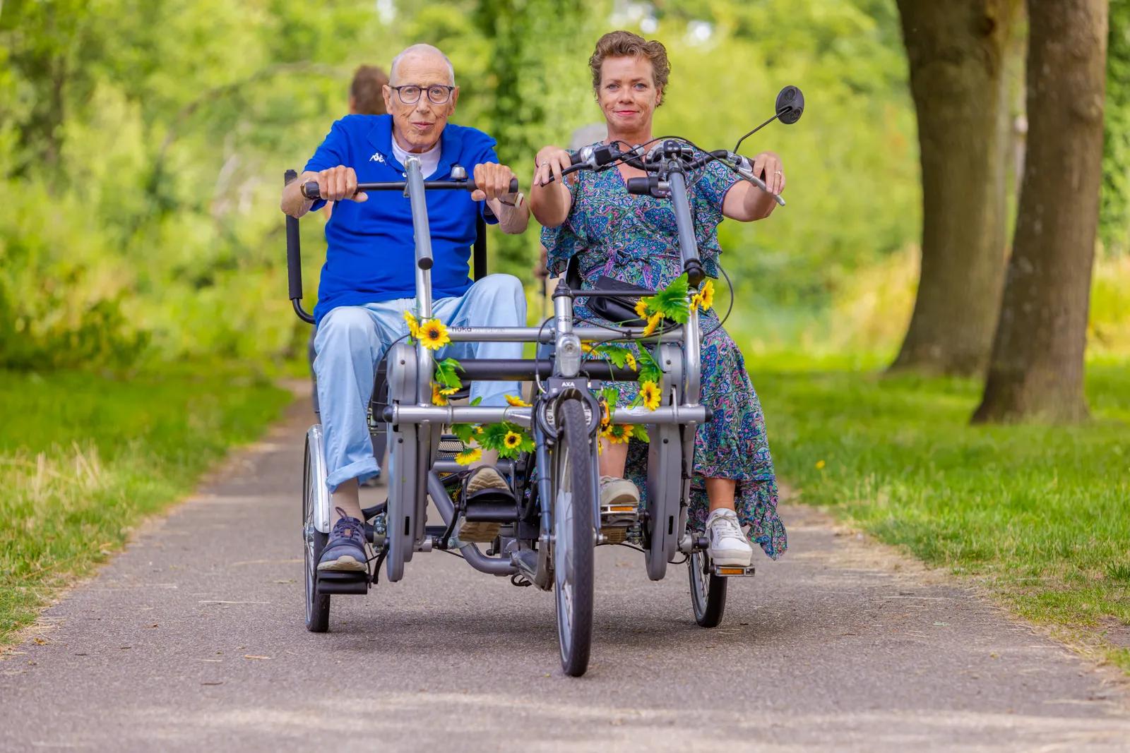 Een oudere en vrijwilliger op de duofiets