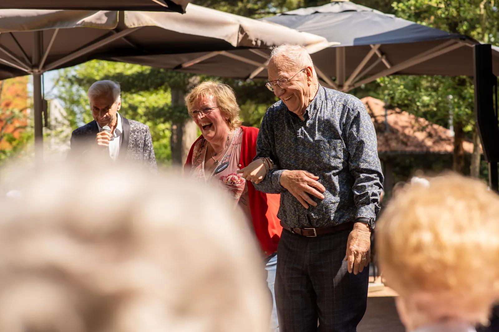 Een activiteitenbegeleidster met een oudere haken in elkaars arm