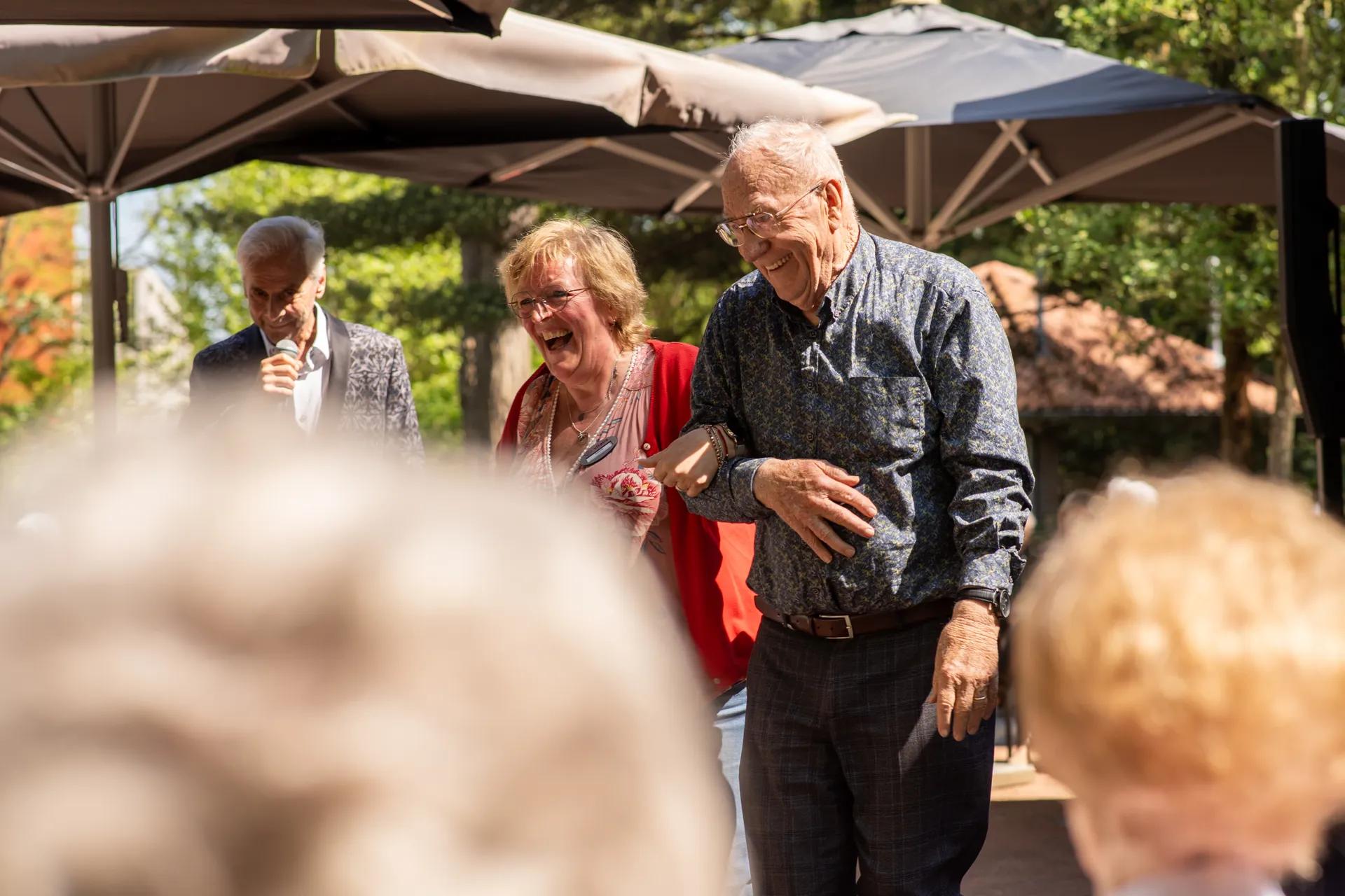 Een activiteitenbegeleidster met een oudere haken in elkaars arm